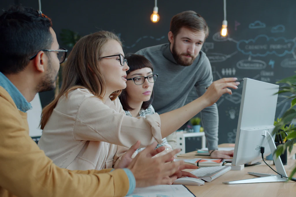 Equipo trabajando junto frente a una pantalla